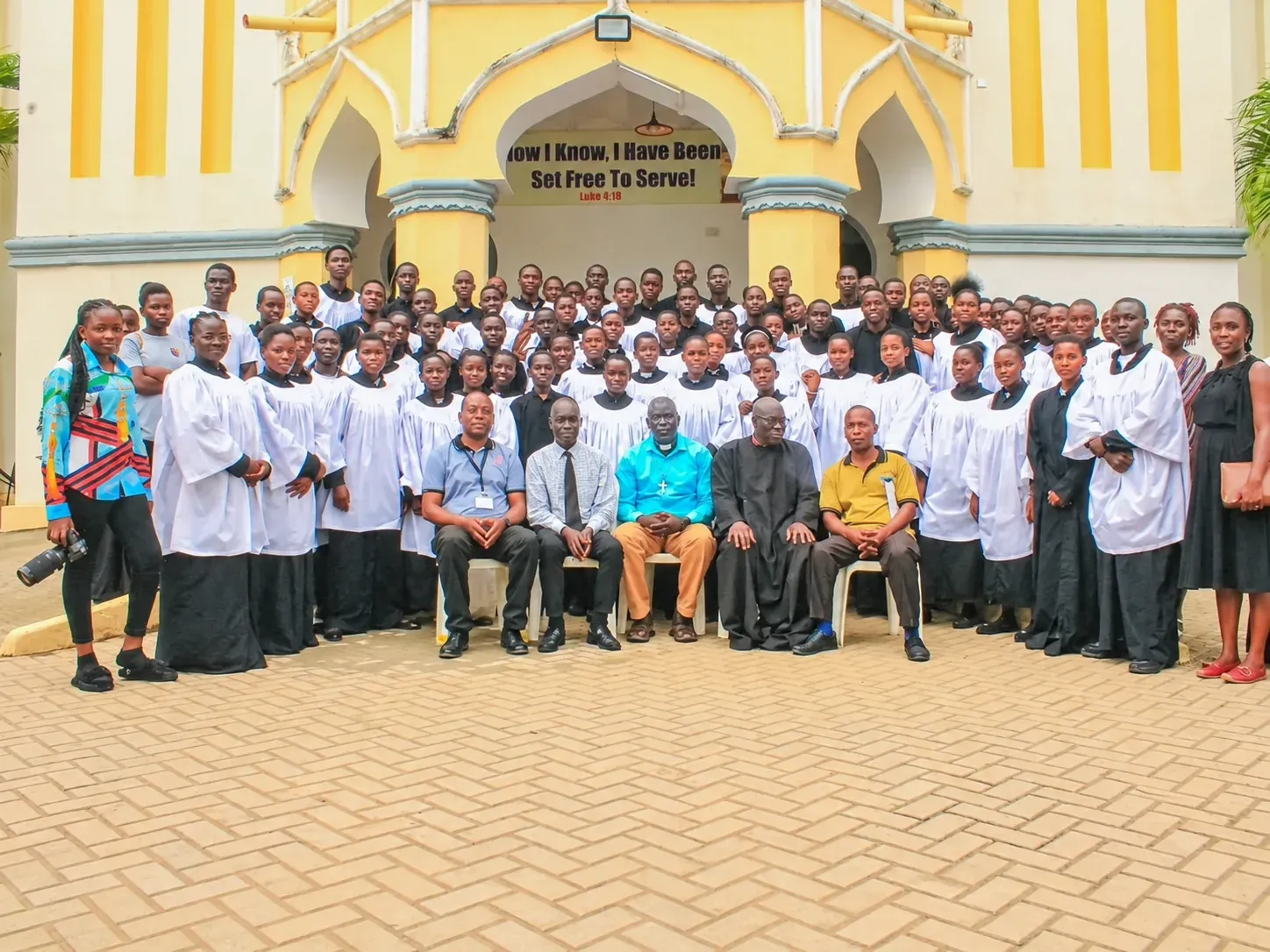Amus College School choir and staff gathered outside the church