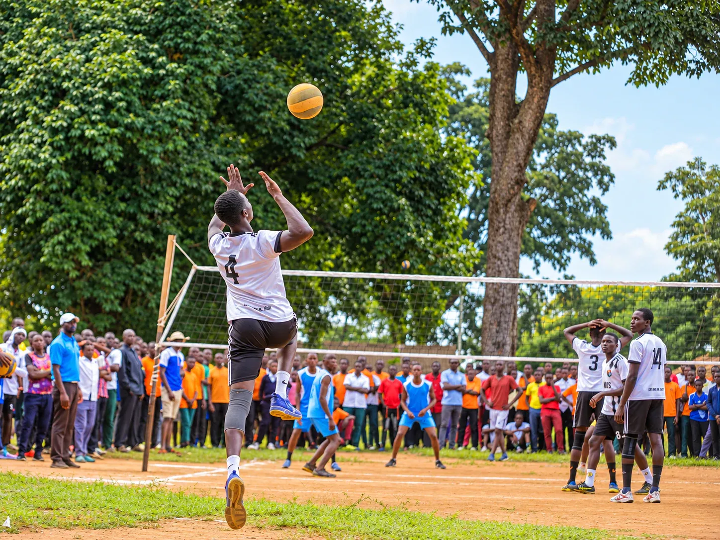 Amus College School student jumping to play volleyball before a crowd