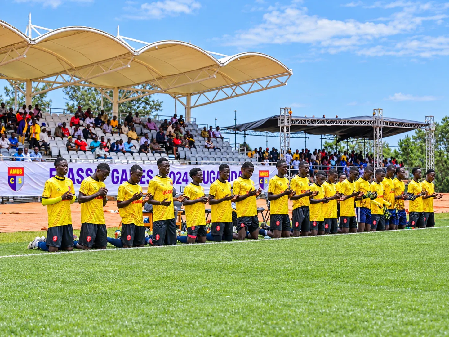 Amus College School football team in prayer before a match